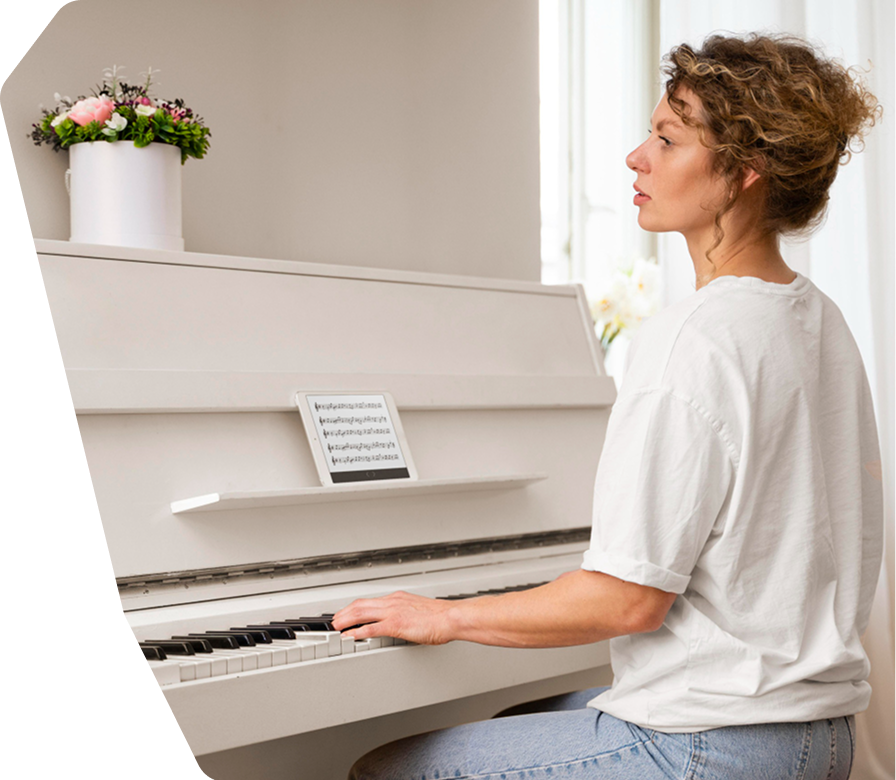 Pianistin an einem weißen Klavier in einem hellen Wohnraum