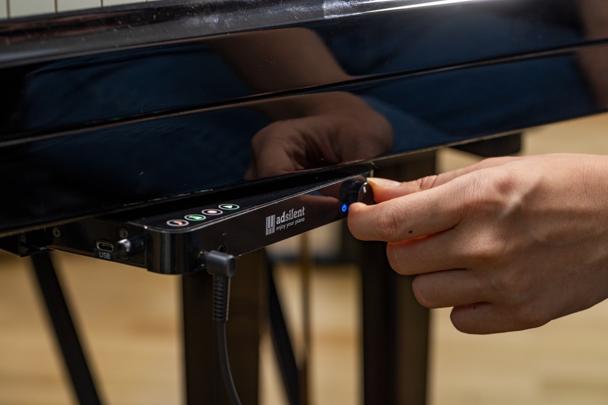 Bedienung des adSilent2-Systems unter der Tastatur eines Klaviers